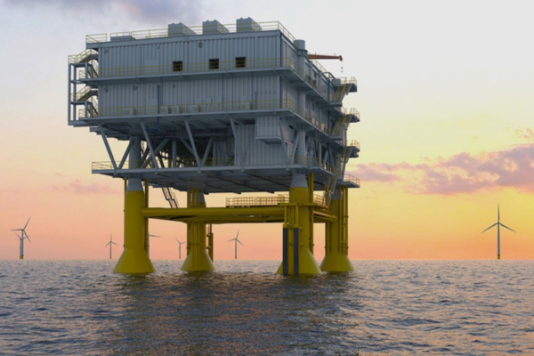 An offshore oil platform stands in the ocean at sunset, with several wind turbines visible in the background, capturing a perfect scene for your next SACS brochure.