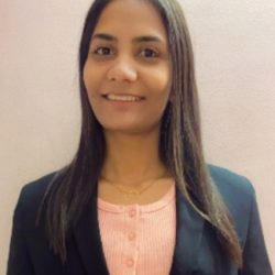 A woman with long brown hair, wearing a pink shirt and a black blazer, smiles at the camera against a plain background, embodying the precision of Highway Design.