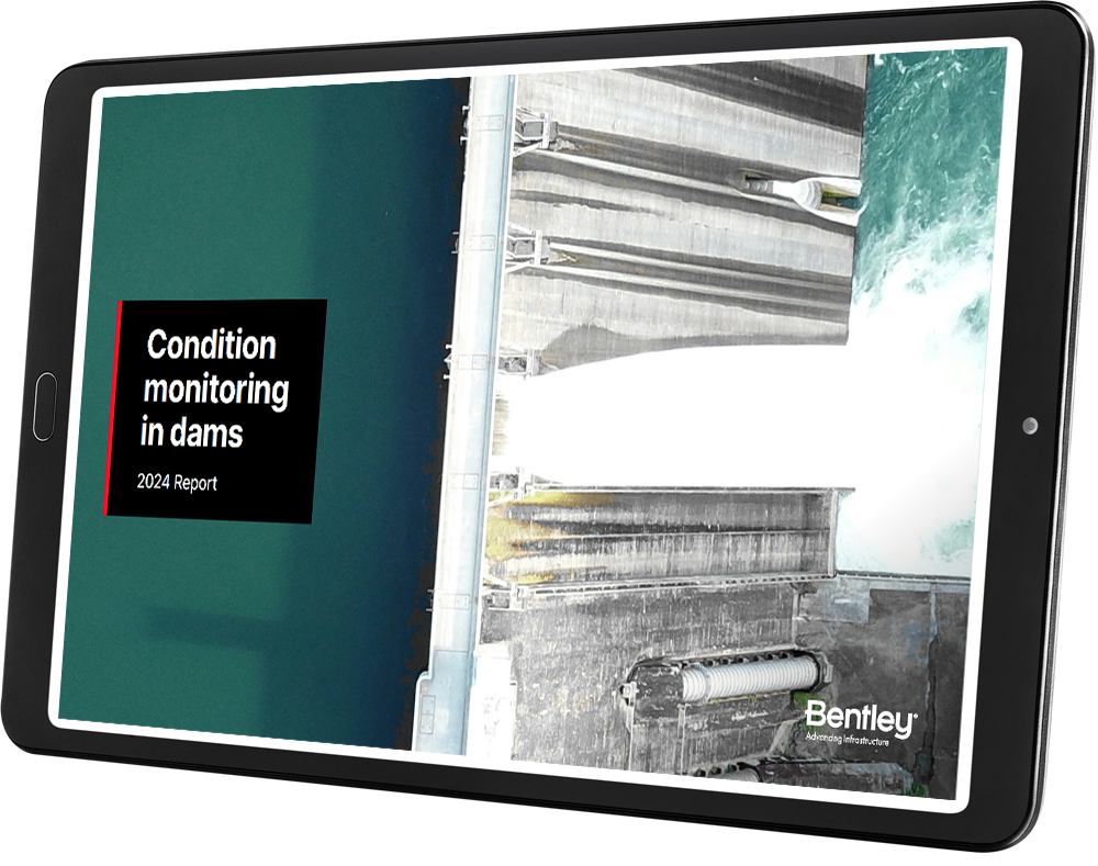 A digital tablet displaying a report cover titled "CMR Dam Report - Condition Monitoring in Dams - 2024 Report" with an aerial image of a dam in operation. The text includes the name "Bentley.